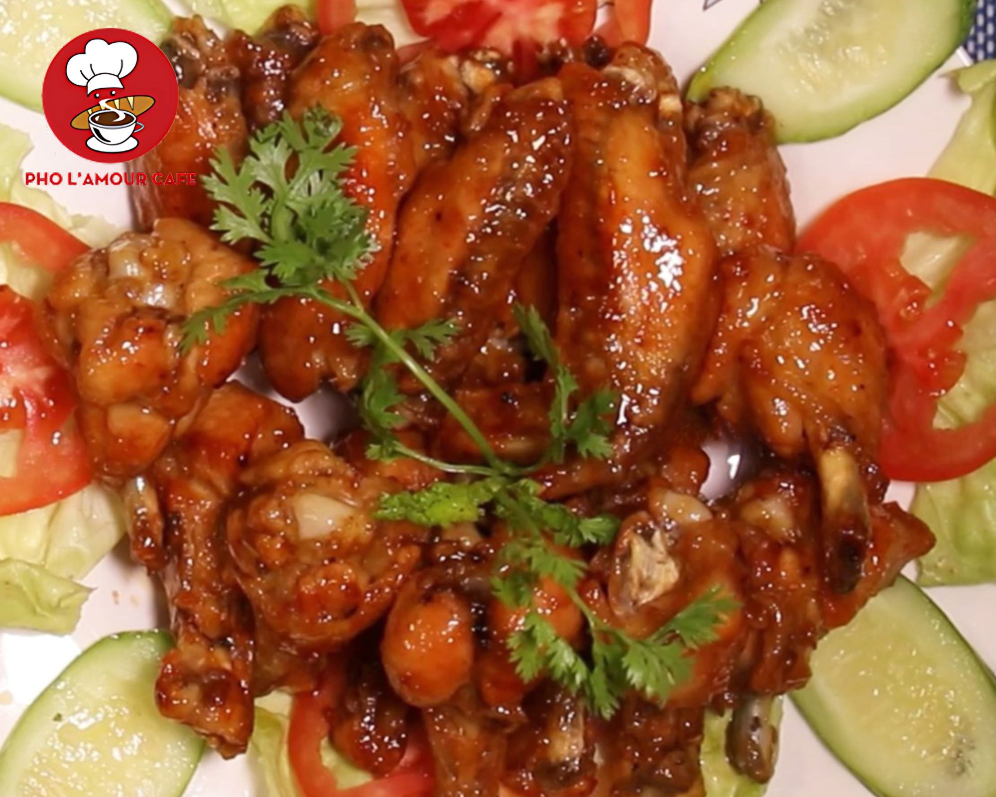 Crispy Vietnamese fish sauce chicken wings garnished with cilantro, tomatoes, and cucumber slices
